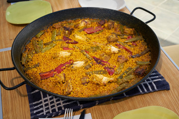 Large flat frying pan with cooked homemade Spanish paella with variety of meats