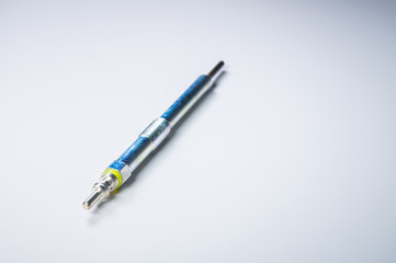 New diesel engine glow plug on a gray background. The concept of new spare parts for diesel internal combustion engines