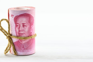 Roll of hundred Chinese yuan bills with face of Mao zedong