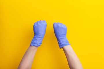Female hand in medical glove is clenched into fist