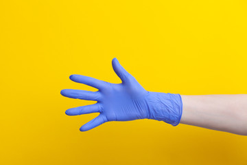 Doctor hand in medical lilac rubber glove showing palm, five fingers
