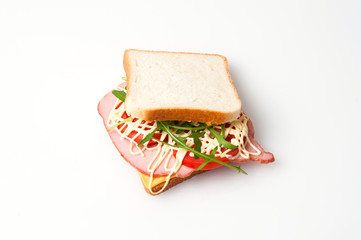Sandwich of bread for toast, sturgeon, tomatoes, arugula, cheese and mayonnaise on a white background view from the top flat lay