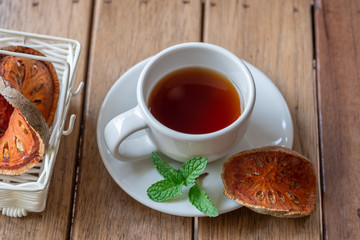 Hot Bael Herbal Tea Fruits, herbs for health on the wood floor.
