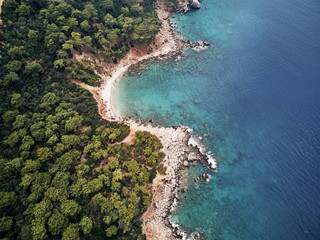 turkey, aerial drone perspective of deep blue and turquoise water of the mediterranean sea. Moody weather with many green trees. nice sandy white yellow beach