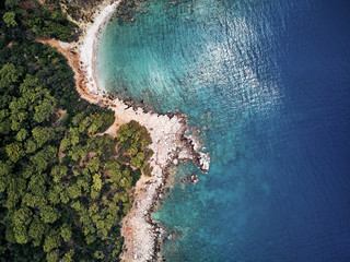 turkey, aerial drone perspective of deep blue and turquoise water of the mediterranean sea. Moody weather with many green trees. nice sandy white yellow beach