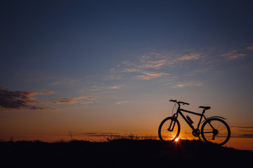 Fototapeta na wymiar silhouette of a bicycle on the sunset sky