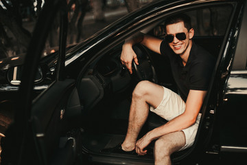 Young man sitting in his car.