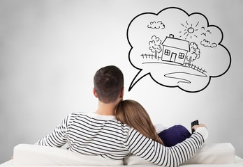 Young couple sitting on the sofa and thinking for house