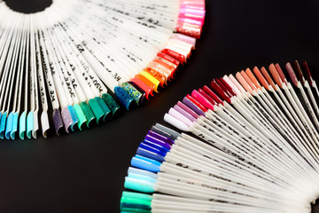 A palette of nails polish for professional manicures on a dark background