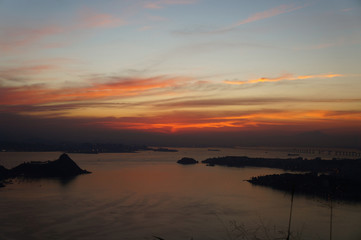 Sunset at Niteroi and Rio de Janeiro cities, Brazil. View of tourist spots in the cities, such as Guanabara Bay, Sugarloaf Cable Car, Christ the Redeemer statue