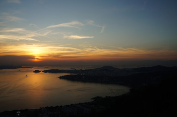 Fototapeta na wymiar Sunset at Niteroi and Rio de Janeiro cities, Brazil. View of tourist spots in the cities, such as Guanabara Bay, Sugarloaf Cable Car, Christ the Redeemer statue