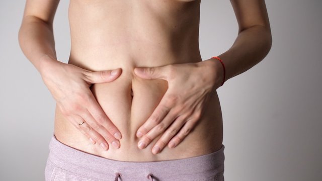 Attractive Young Woman With Bare Belly. Close-up Of Female Belly Of Sexy Girl. White Female's Fit Body And Tan Skin. Caucasian Woman's Flat Stomach And Arms. Weight Loss During Quarantine