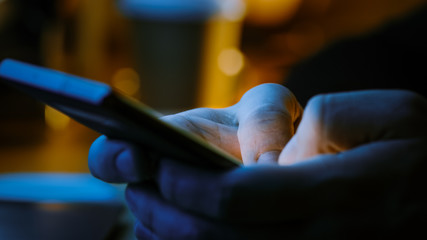Person Holding Touch Screen Smartphone Device and Typing Message. Concept of Email Writing, Chatting in Social Media Apps, Sending an SMS, Taking Note. Close-up Macro Side View