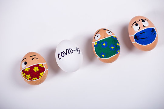 Diverse chicken eggs with doodle faces wearing medical masks. Conceptual image of Easter during Corona virus epidemic lockdown. Quarantine at home.