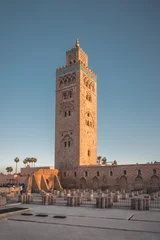Poster Koutoubia Mosque minaret during twilight located at medina quarter of Marrakesh, Morocco, North Africa. Sunset view on a sunny day with blue sky. © Mathias