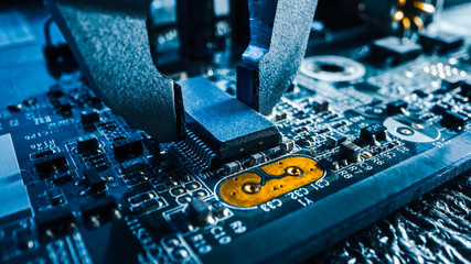 Macro Close-up Shot of Factory Machine at Work: Printed Circuit Board Being Assembled with Robotic...