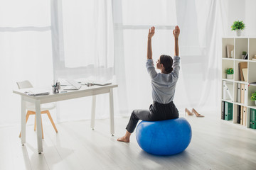 executive businesswoman stretching on fitness balls in office