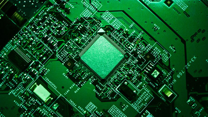 Macro Close-up Shot of Microchip, CPU Processor on Green Printed Circuit Board, Computer Motherboard with Components Inside of Electronic Device, Part of Supercomputer. Lit by Green Light.