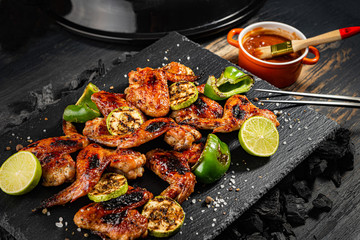 grilled chicken wings and vegetables on a stone dish