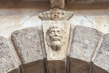 bas-relief of a man's face above the old gate