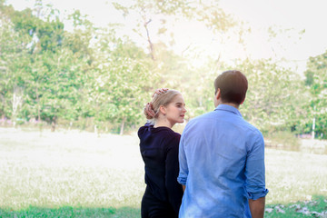 Sweet couple relaxing in park, young beautiful lover walking and spending time together and having romantic moment in summer garden, love and romantic date concept