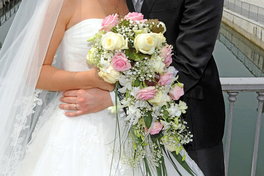 generic wedding detail  photo - flower bouquet of bride embraced to the groom