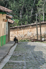 Man sitting on sidewalk cord