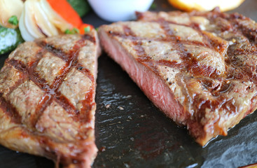 Closeup Cut Juicy Medium Grilled Ribeye Steak Served on Hot Stone Plate