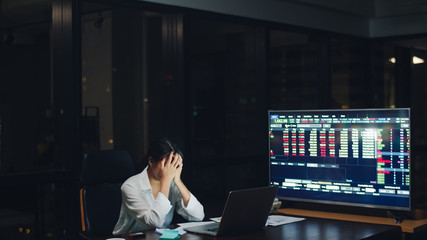 Millennial young Chinese businesswoman working late night stress out with project research problem...