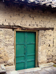 Puerta de madera antigua, verde con viga de madera en casa de adobe, teja, Cuenca, Ecuador