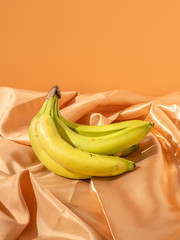 Fototapeta na wymiar Bananas on a gold satin sheet. An artistic take on a healthy and organic snack. 