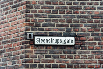 Fototapeta na wymiar Street name sign on old brick wall in Oslo. Steenstrups gate