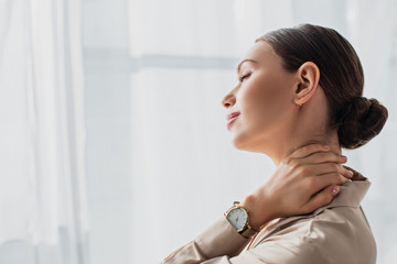 attractive young businesswoman stretching neck in modern office