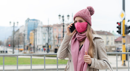 Woman with fashion mask using her phone