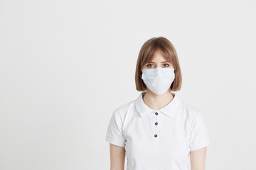 A young girl doctor in a surgical mask is preparing to receive patients with the virus.