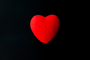 Red heart, on the black velvet background