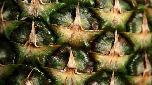 Close up of fresh pineapple ananas fruit skin as rotating food background. Healthy eating