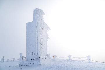 A frosty mound on a summit of Snezka mountain,trigonometric point located on borders with Poland. Winter picture of Czech national park called Krkonose.