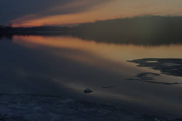 sunset over lake as ice goes out