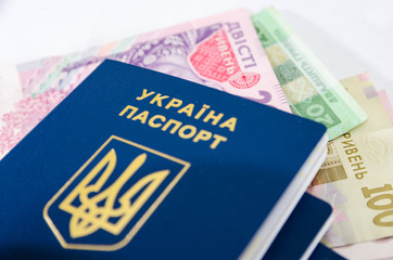 Ukrainian passport and hryvnia on white. Close-up.