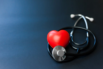 Red heart and stethoscope on blue paper. Flat lay essential items for doctor using treat and care...