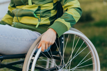 Close up of a young woman in a wheelchair while walking in a park on a sunny day. Recovery and...