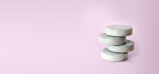 Fototapeta na wymiar Green pills isolated on pink background