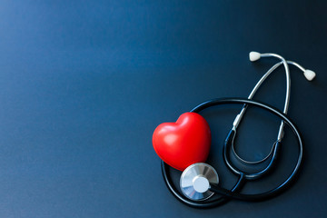 Red heart and stethoscope on blue paper. Flat lay essential items for doctor using treat and care...
