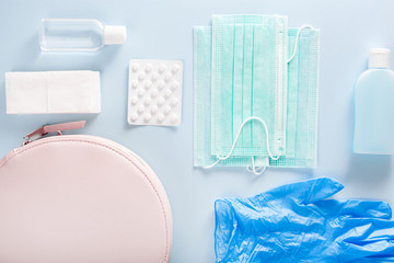 protective medical mask, sanitizer gel and gloves in pink bag. protective measures against virus, bacteria