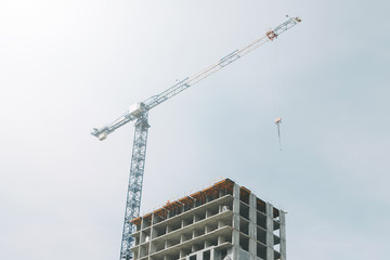 Fototapeta premium Cranes in the construction of high-rise buildings. Construction of floor coverings. Construction of a building made of solid concrete.