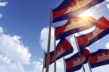 Naklejka premium Cambodia flags waving in the wind against a blue sky. 3D Rendering