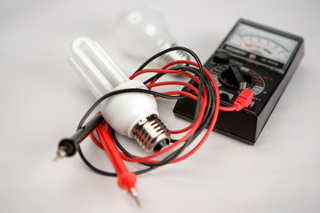 Fototapeta premium Ampoules led et a incandescence, voltmetre sur fond blanc
