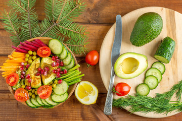 vegan salad with avocado and pomegranate  on a wooden table, concept of vegan and healthy food