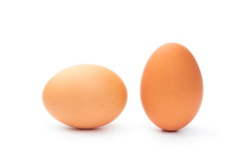 Two fresh brown chicken eggs on a white background